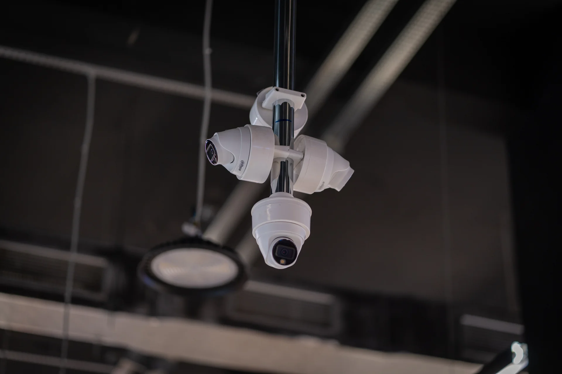 A cluster of four dome cameras on one suspension pole, each facing a different direction.