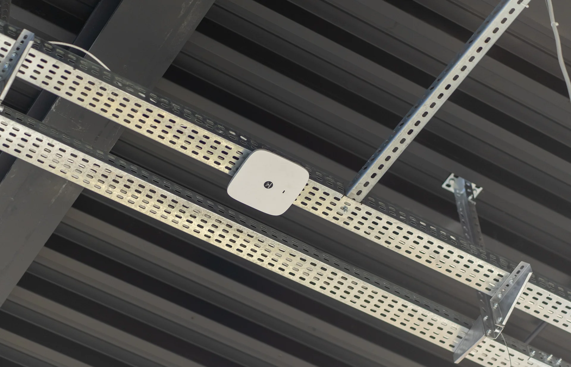 Overhead cable trays running across the ceiling structure.